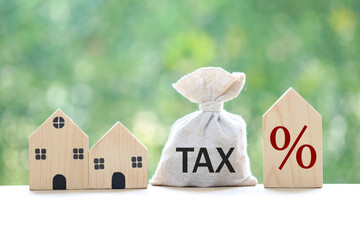 Estate tax, Model house and percentage symbol icon and stack of coins money on natural green...