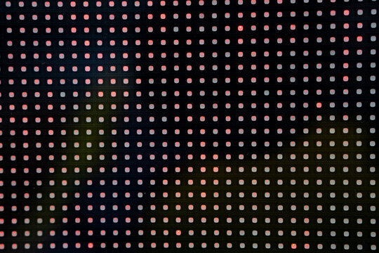 Led light grid with red and green dots creating abstract digital pattern.