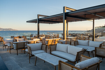 Elegant beachfront dining setup with ocean views, fine glassware, and warm golde