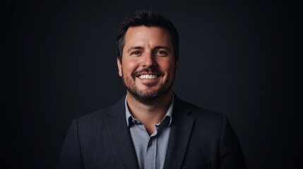 Smiling man, headshot, dark background, professional portrait, website use