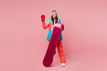 Full body young woman wear blue padded jacket ski goggles mask spend weekend winter season in...