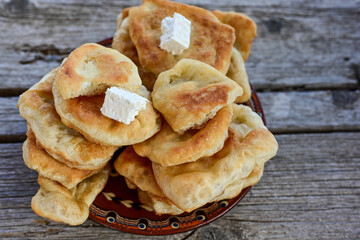 Traditional Bulgarian home made deep fried  patties  covered with sugar  оn rustic backgroud.Mekitsa or Mekica,  on wooden  rustic  background. Made of kneaded dough that is deep fried 