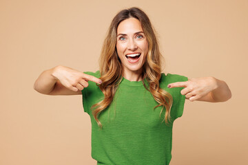 Young surprised happy fun woman she wear green t-shirt casual clothes point index finger on herself...