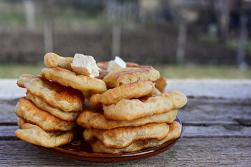 Traditional Bulgarian home made deep fried  patties  covered with sugar  оn rustic backgroud.Mekitsa or Mekica,  on wooden  rustic  background. Made of kneaded dough that is deep fried 
