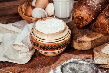 rye bread with raisins, dried apricots, sunflower seeds, caraway seeds, two loaves of bread on a wooden background, flour, sieve, rolling pin, eggs, homemade bread, wheat ears, black bread with butter