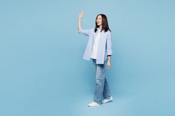 Full body side profile view happy young Caucasian woman she wears shirt casual clothes walking...