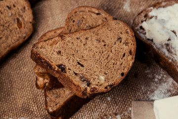 rye bread with raisins, dried apricots, sunflower seeds, caraway seeds, two loaves of bread on a wooden background, flour, sieve, rolling pin, eggs, homemade bread, wheat ears, black bread with butter
