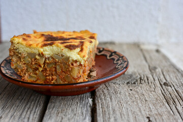  Potato and minced meat  Casserole  with   parmesan cheese and garlic on wooden rustic bakcground.  Bulgarian moussaka