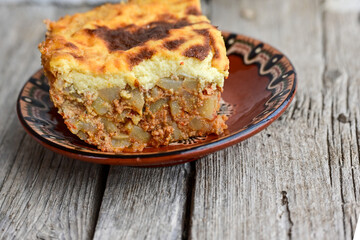  Potato and minced meat  Casserole  with   parmesan cheese and garlic on wooden rustic bakcground.  Bulgarian moussaka
