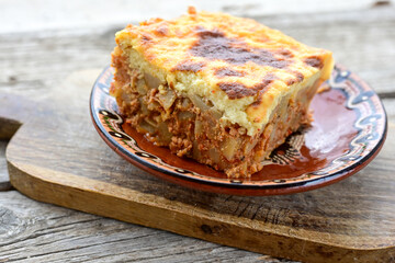  Potato and minced meat  Casserole  with   parmesan cheese and garlic on wooden rustic bakcground.  Bulgarian moussaka