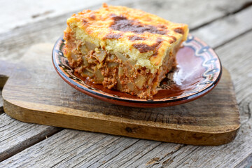  Potato and minced meat  Casserole  with   parmesan cheese and garlic on wooden rustic bakcground.  Bulgarian moussaka