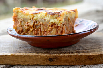  Potato and minced meat  Casserole  with   parmesan cheese and garlic on wooden rustic bakcground.  Bulgarian moussaka