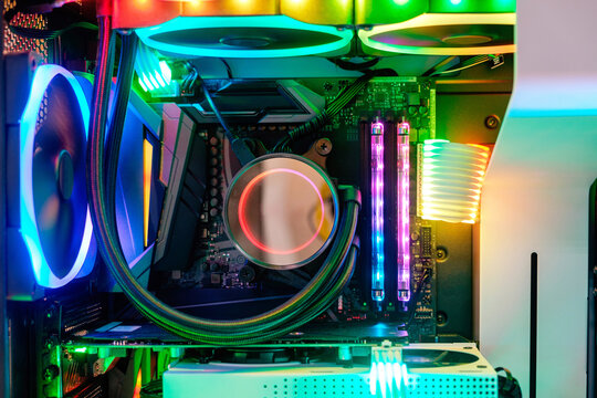 Close-up inside Hi-performance custom computer desktop with liquid pump that installed on socket CPU processor and cooling fan for cooling airflow with LED neon multicolor light show status on working