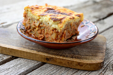  Potato and minced meat  Casserole  with   parmesan cheese and garlic on wooden rustic bakcground.  Bulgarian moussaka