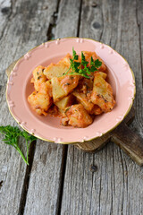 Homemade stew of  potatoes, peppers, onions, tomatoes and eggplant close-up in a   plate on wooden background