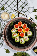 green pancakes rolls with Philadelphia cheese, red fish, red caviar, lemon, olives, pancakes with caviar, spinach, flatlay, Maslenitsa, Japanese rolls, cream cheese with salmon, still life