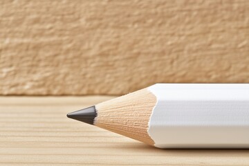 Obraz premium White pencil tip on wooden surface with neutral background. education and creativity