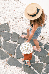 A mom and her baby are walking around a resort town in the summer.