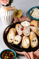 sweet rolls, pancakes with cottage cheese, raisins, apples, powdered sugar and dried cranberries, pancakes with sour cream, flatlay, beautiful light composition with dessert, roses, carnation flowers