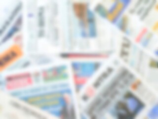 Background view showcasing a collection of newspapers with a bokeh effect.