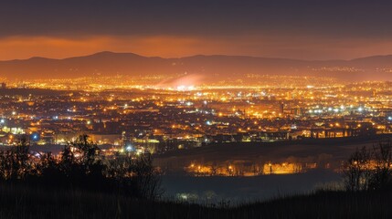 Obraz premium Extensive city view with glowing lights and distant mountains