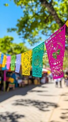 Colorful papel picado banners hanging over a festive street during Cinco de Mayo celebrations