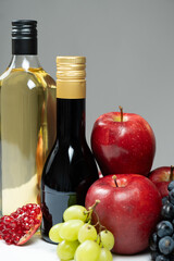 Vinegars in glass bottles among fruits, vertical photo, space for text