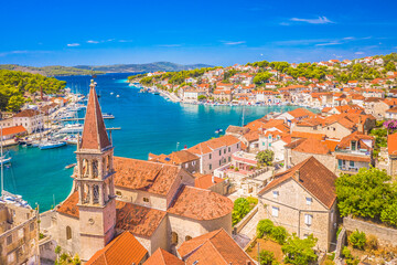 A picturesque view of Milna, a traditional fishing village on Brac Island, Croatia, featuring its scenic marina, and the crystal-clear Adriatic Sea, making it a popular tourist destination