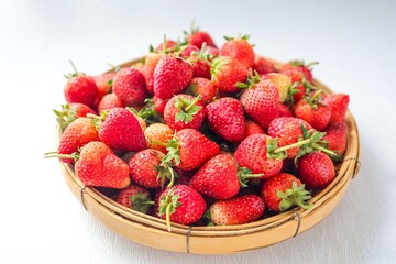 Pile of Strawberries in a basket on white background