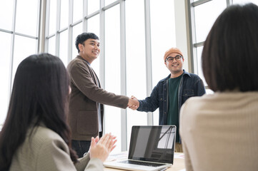 Happy Asian business men holding hands, brainstorming, talking about analysis, innovation and collaboration. Online business, sales techniques, strategic planning
