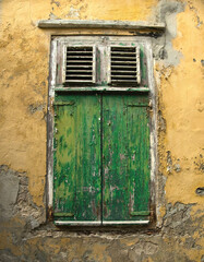Detailaufnahme eines verfallenen historischen Gebäudes auf Curacao mit kolonialer Architektur und bunter Fassade, ein eindrucksvolles Beispiel für die einzigartige Karibikarchitektur.