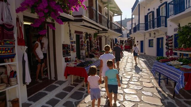 A lively street market scene in a Greek village, captured from a low angle, showcasing vibrant colors and local life in a video style.