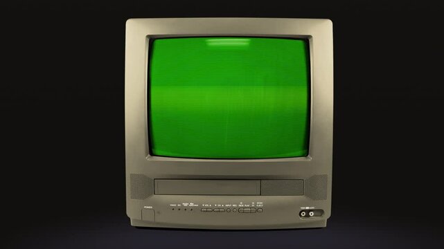 Old grey TV on a black background with a green screen. TV from the 90s with chromakey. CRT screen of a vintage TV with flickering and interference. Looping animation. 4K video.	
