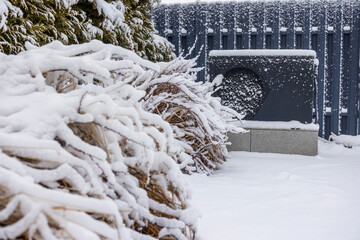 Outdoor heat pump unit covered in snow, providing energy-efficient heating for a swimming pool in...