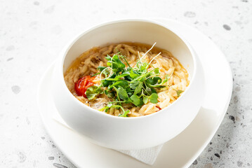 A stylish bowl of pasta with fresh herbs and cherry tomatoes, served on a textured surface. Perfect for food photography and culinary presentations.