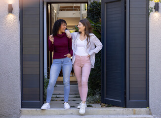 Happy lesbian couple holding key to new home in doorway