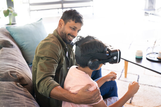 indian father and son using VR headset, bonding and experiencing virtual reality together