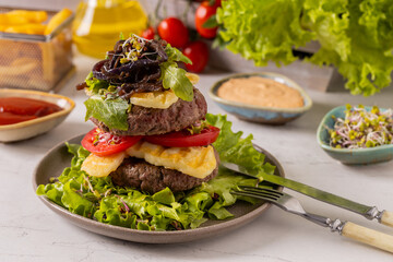 Beef burger without a bun, served on a plate with halloumi cheese.