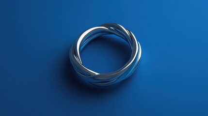 Minimalist twisted silver band with a contemporary design, softly illuminated against a royal blue surface