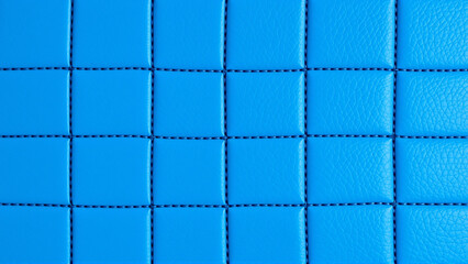 Fototapeta premium The surface texture of artificial leather is blue, the surface is stitched in the form of diamonds, squares, rectangles. Eco-leather in a kilt. 