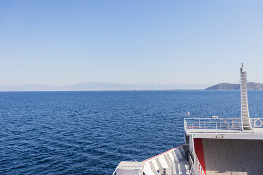 Ferry Crossing Calm Blue Sea with Distant Mountains and Clear Skies