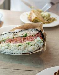 Sushi roll with a variety of ingredients including tuna, avocado, and cucumber