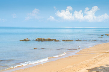 Serene beach with calm blue waters and clouds.