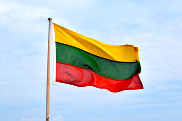 The flag of Lithuania, on a light background, the wind flies the flag