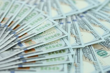 Many hundred dollar bills new banknotes in big pile under the natural light