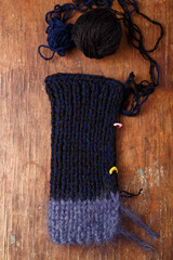 Knitting dark blue mohair and acrylic yarn balls on old wooden table background. Part of a knit...