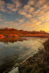Beautiful nature on the lake ,sunrise from the hills, landscape photoshoot of beautiful red and orange sunrise , sky and clouds , reflections on water . Breathtaking sunrise , place of silence 