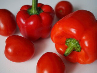 Red vegetables. Sweet bell peppers and tomatoes on a white background.
