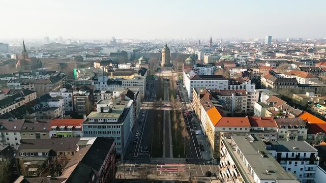 Drone flight over Mannheim's Augustaanlage towards the iconic Wasserturm on a clear, sunny winter day.