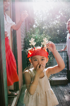 Young Asian girl holding nose outside being silly